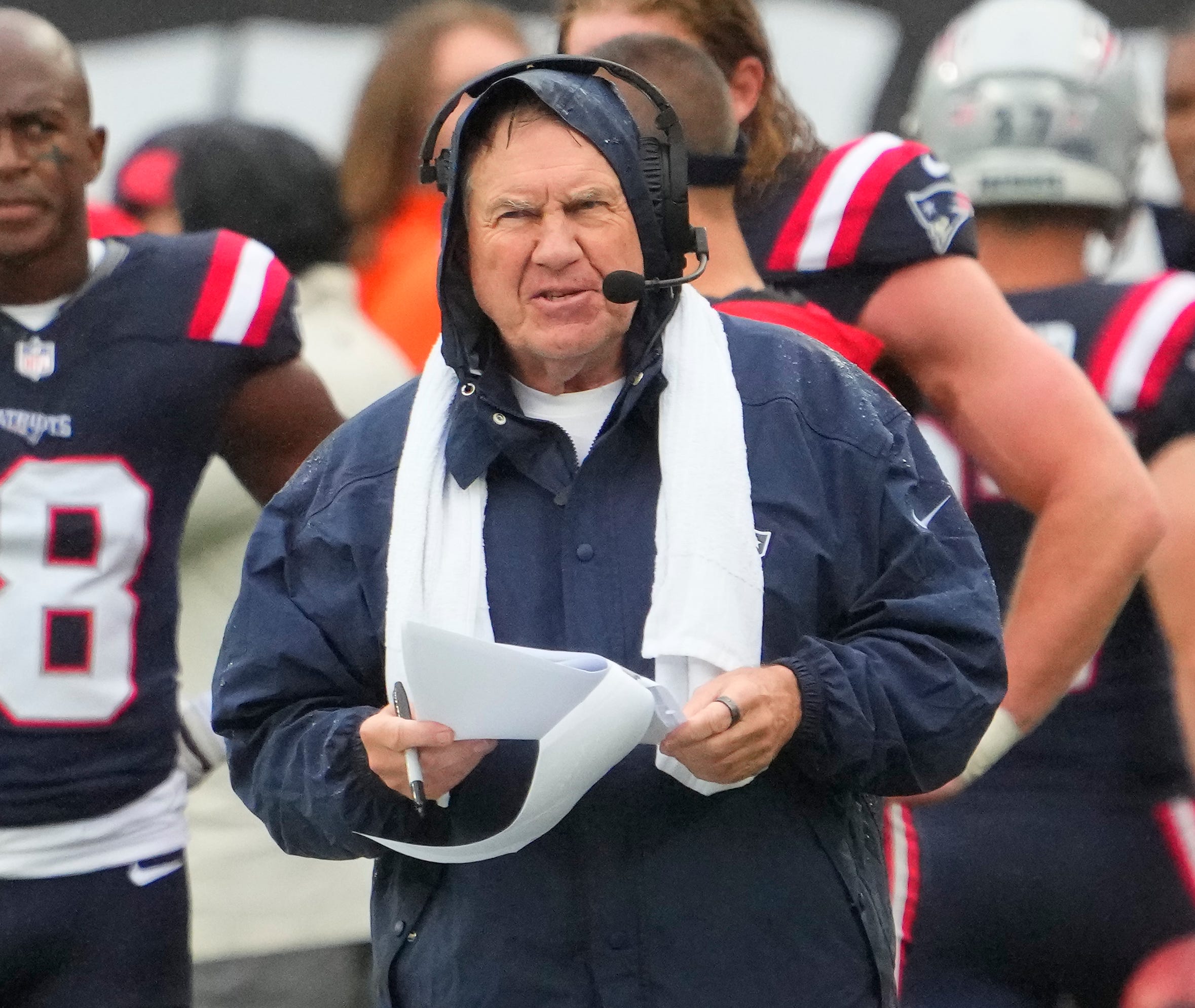 Patriots coach Bill Belichick battles the rainy weather in preparation for Sunday's game against the Jets.
