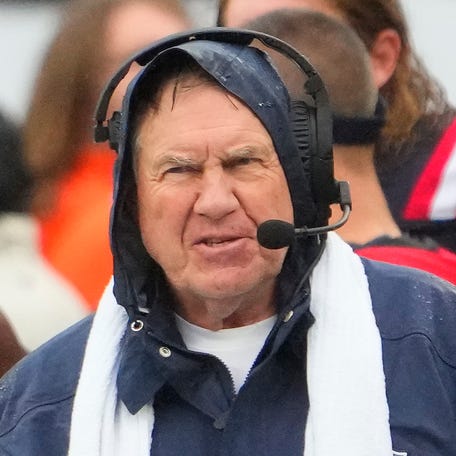 Patriots coach Bill Belichick battles the rainy weather in preparation for Sunday's game against the Jets.