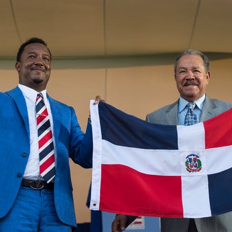 Hall of Fame Inductee Pedro Martinez (left) and Hall of Famer Juan Marichal hold up the Dominican Republic flat at the end of Martinez's acceptance speech during the 2015 induction ceremonies.