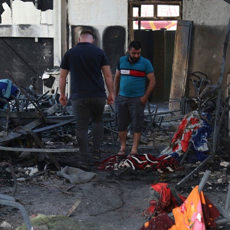 People gather at the site of a fatal fire, in the district of Hamdaniya, Nineveh province, Iraq, Wednesday, Sept. 27, 2023. A fire that raced through a hall hosting a Christian wedding in northern Iraq killed multiple people, authorities said Wednesday.