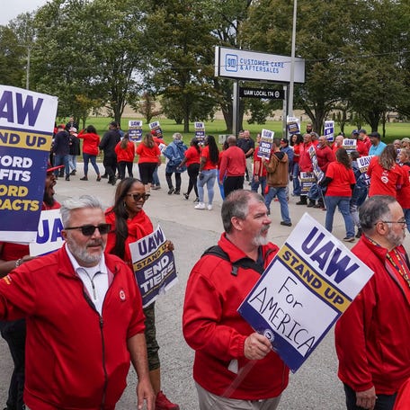 Workers walk in a circle while picketing at General Motors Willow Run Redistribution in Belleville on Tuesday, September 26, 2023, as President Joe Biden arrives during his stop to Michigan.