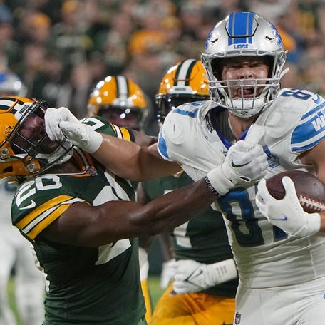 Detroit Lions tight end Sam LaPorta (87) stiff-arms Green Bay Packers safety Rudy Ford (20).