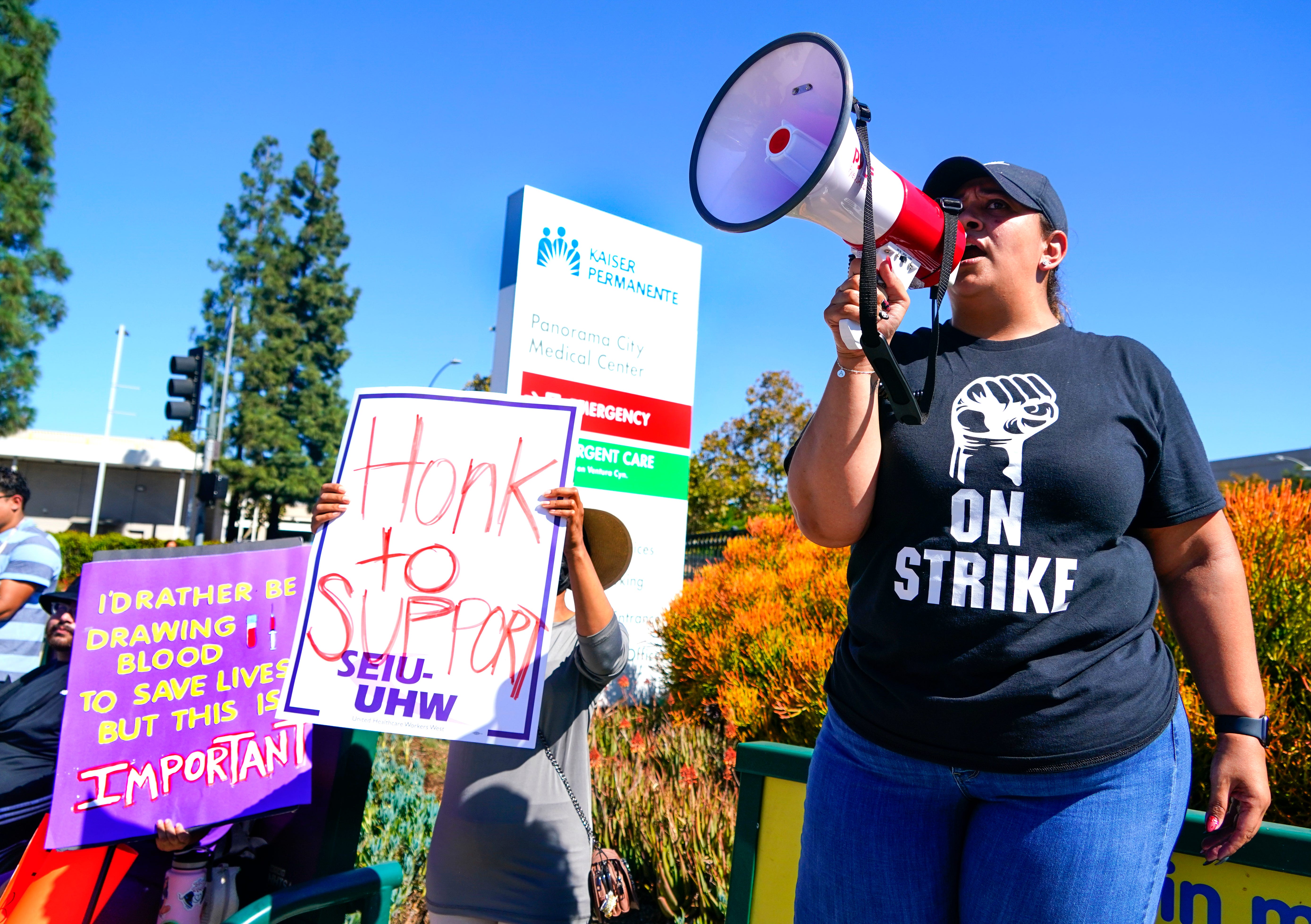 Jovanna Segura uses a bullhorn to lead chants with striking health care workers in front of Kaiser Permanente Medical Center in Panorama City, Calif. on Wednesday, Oct. 4, 2023. More than 75,000 Kaiser Permanente workers walked off the job Wednesday in what is being called the largest healthcare strike in U.S. history. Kaiser Permanente Unions and the healthcare provider in negotiations for a new contract, but workers still opted to hold a three-day   labor strike.