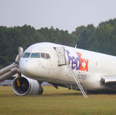 A FedEx 757 sits on a landing strip Thursday, Oct. 5, 2023 at the Chattanooga Metropolitan Airport after crash landing late Wednesday evening. Officials say the FedEx plane skidded off the runway during a crash landing when its landing gear did not descend, but no one was injured. (Olivia Ross /Chattanooga Times Free Press via AP)