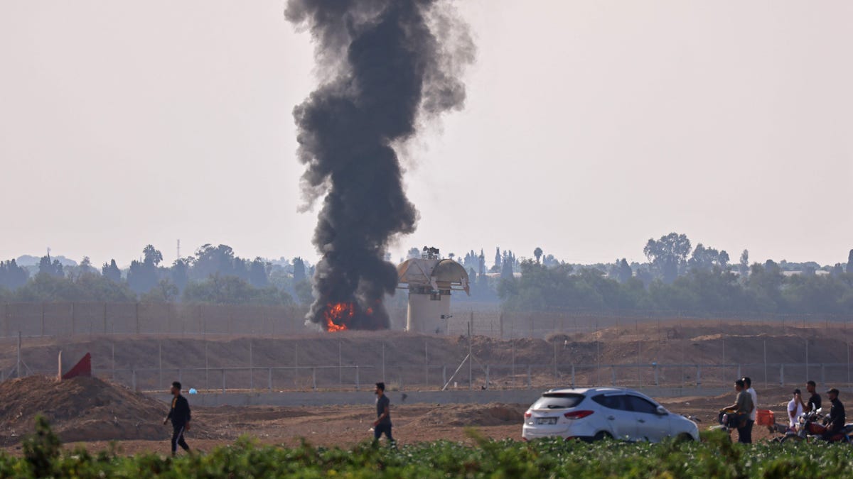 A picture taken from Khan Yunis in the southern Gaza Strip shows smoke billowing next to an Israeli observation tower on Oct. 7, 2023.
