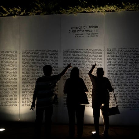 People look for names of fallen soldiers before a ceremony commemorating the 50th anniversary of the 1973 Yom Kippur war at the Armored Corps memorial site in Latrun, Israel, Wednesday, Sept. 27, 2023.