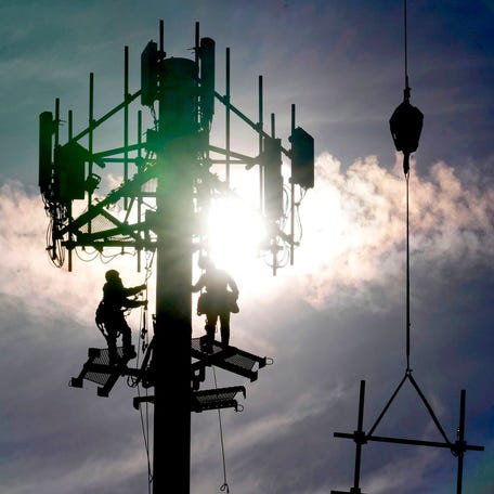 A crew with Tower Warriors Construction, out of Plainfield, Illinois work on installing cellular equipment for Dish Network Wireless on a cell communications tower in the Fox Point shopping plaza on West Brown Deer Road on Tuesday, March 21, 2023.    Wild Cell Tower 0783