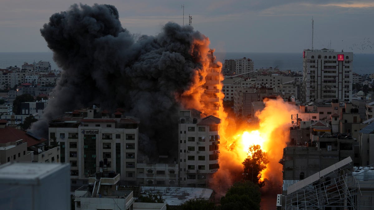 A ball of fire and smoke rise from an explosion on a Palestinian apartment tower following an Israeli air strike in Gaza City, Saturday, Oct. 7, 2023.