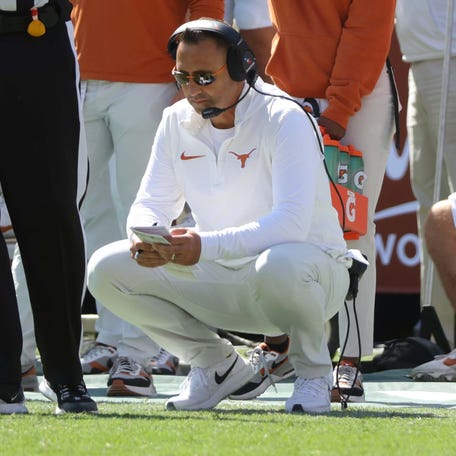 Texas coach Steve Sarkisian kneels on the sideline during the Red River Rivalry game against Oklahoma at the Cotton Bowl in Dallas, Saturday, Oct. 7, 2023.