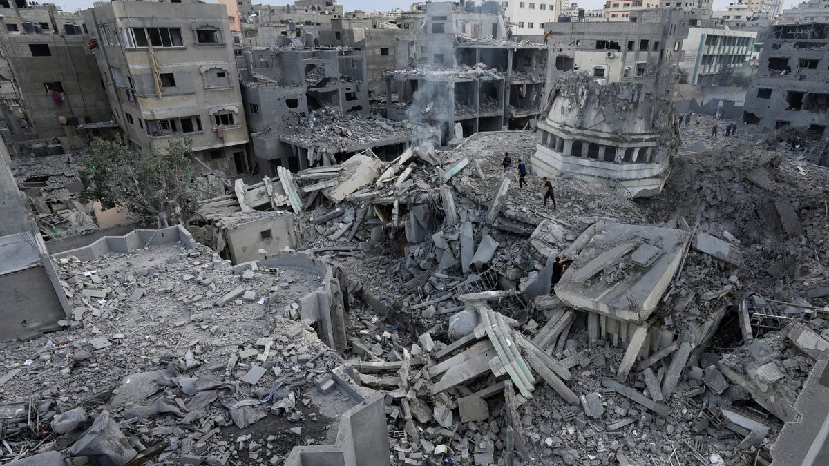 Palestinians inspect the rubble of the Yassin Mosque destroyed after it was hit by an Israeli airstrike at Shati refugee camp in Gaza City, early Monday, Oct. 9, 2023.