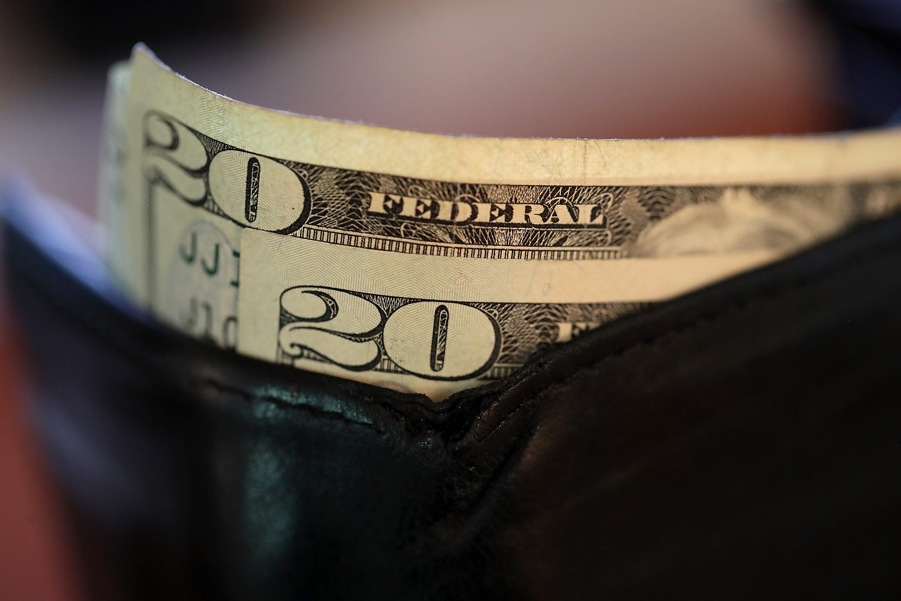 SAN ANSELMO, CA - AUGUST 29: In this Photo Illustration, Twenty dollar bills sit in a wallet on August 29, 2017 in San Anselmo, California. The dollar fell to a two and a half year low to 91.77 Tuesday following the latest missile launch by North Korea. The U.S. dollar index has slipped over 10% since the inauguration of U.S. President Donald Trump. (Photo Illustration by Justin Sullivan/Getty Images)