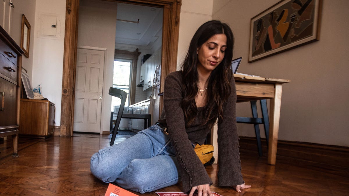 Alana Zeitchik, 38, looks at a poster of one her cousins who is being held captive by Hamas in the Gaza Strip. Zeitchik, photographed in her Brooklyn apartment Oct. 19, 2023, has six cousins that are currently being held by Hamas. "I'm just a person that loves my family very deeply, and I have to advocate for them" she say, "I can't envision sitting here doing nothing."