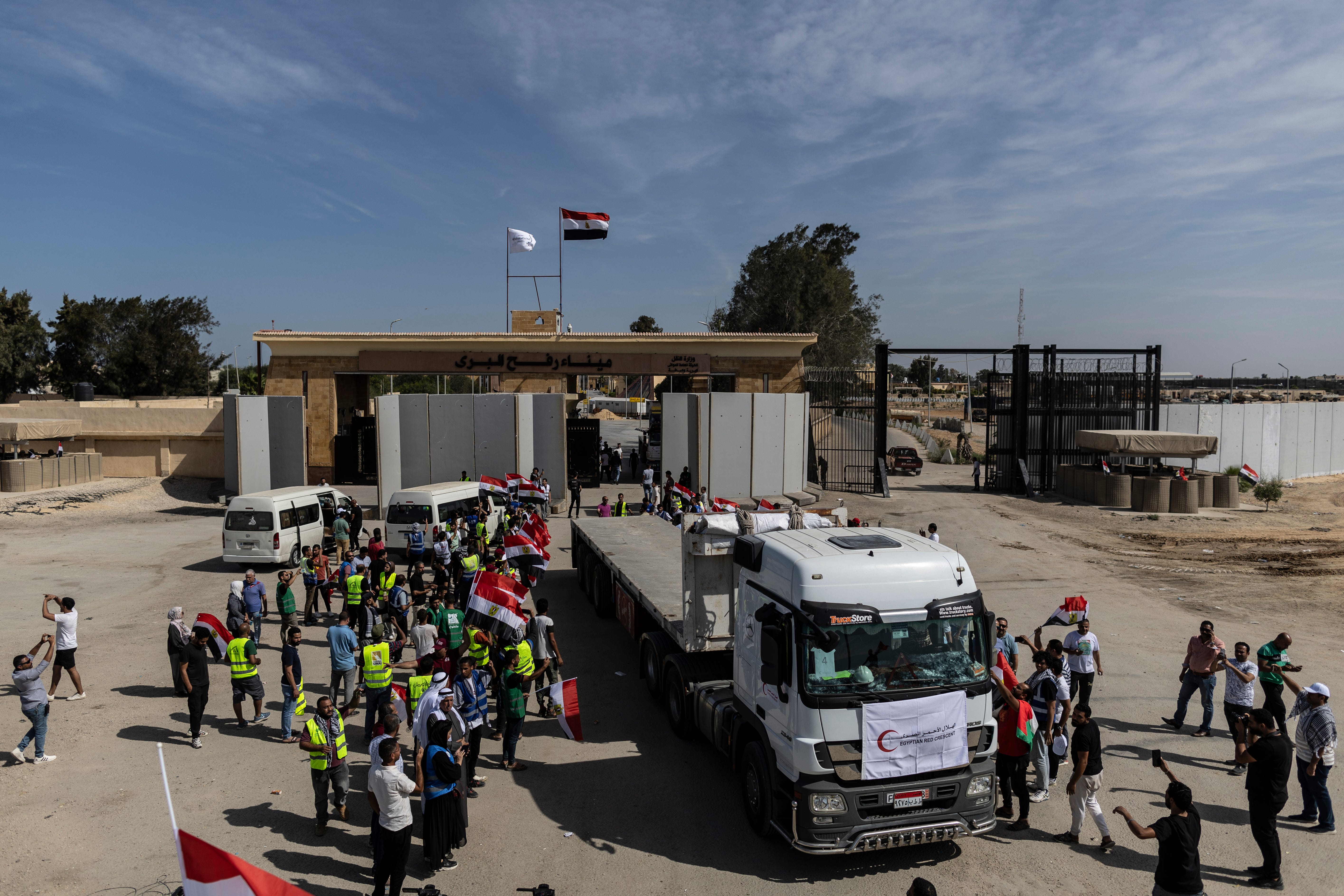 NORTH SINAI, EGYPT - OCTOBER 21: Volunteers and NGOs staff celebrate after unloading aid supplies and returning to Egyptian side of border on October 21, 2023 in North Sinai, Egypt. The aid convoy, organized by a group of Egyptian NGOs, set off Saturday 14th October from Cairo for the Gaza-Egypt border crossing at Rafah. A week of tortuous negotiations followed about when the border, controlled by Egypt on one side and Hamas on the other, would be opened, until   the first trucks were admitted on 21st October. (Photo by Mahmoud Khaled/Getty Images)