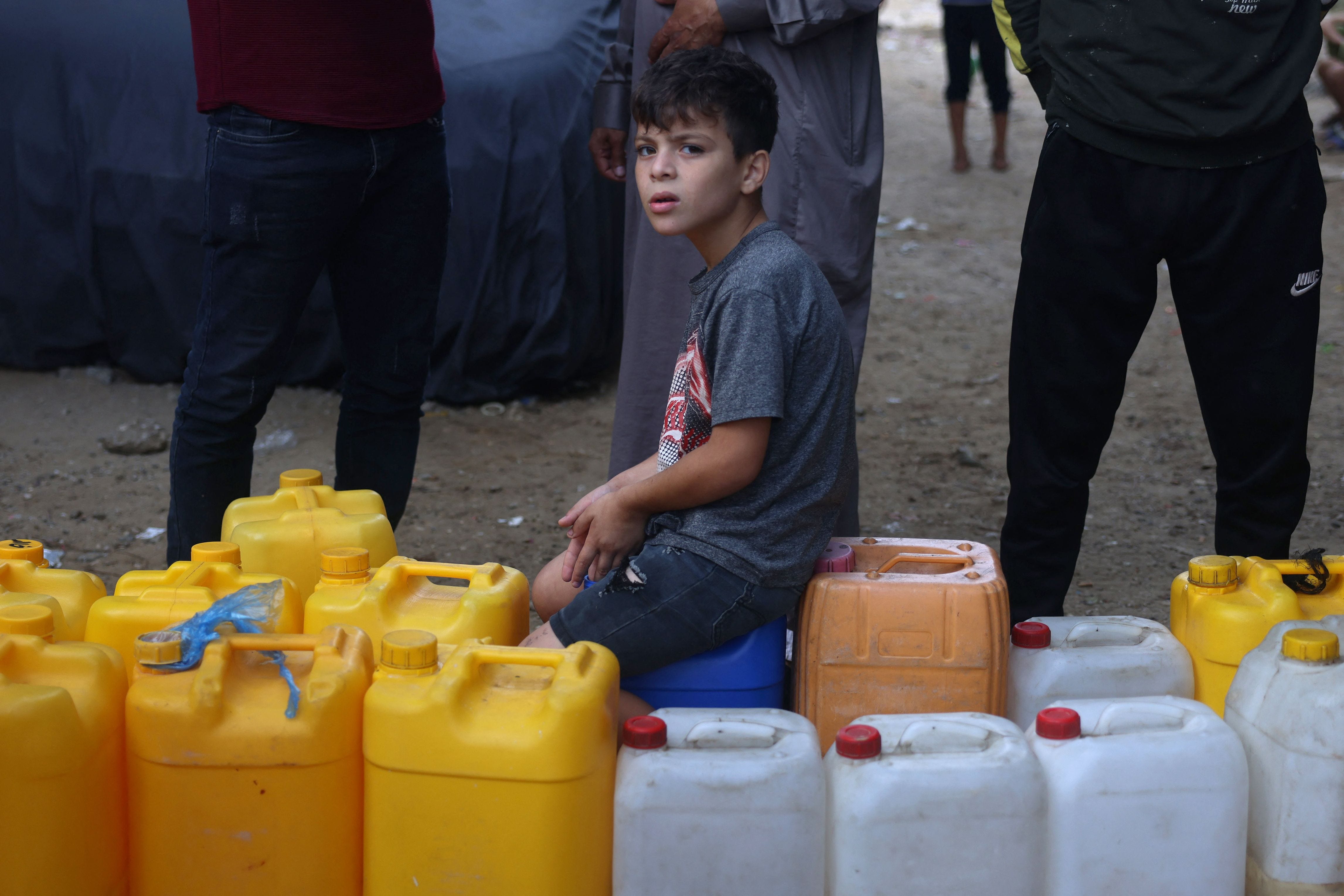 A young Palestinian sits on plastic jerrycans at a water-filling point in Rafah in the southern Gaza Strip on Oct. 28, 2023, amid the ongoing battles between Israel and the Palestinian group Hamas. Thousands of civilians, both Palestinians and Israelis, have died since Oct. 7, 2023, after Palestinian Hamas militants based in the Gaza Strip entered southern Israel in an unprecedented attack, triggering a war declared by Israel on Hamas with retaliatory bombings   on Gaza.