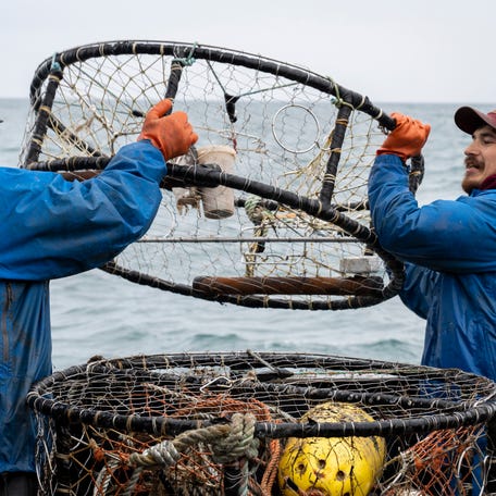 Lyle Ashouwak (left) and Anthony Abell (right) drop crab pots off the Fishing Vessel Insatiable. As the oceans' temperatures rise, fishermen everywhere are forced to adapt to harvesting different species. Garrett Kavanaugh, captain of the Fishing Vessel Insatiable out of the port of Kodiak Island, has made large investments in equipment, fuel and labor, betting on Dungeness crabs as the future of his Alaskan fishing business.