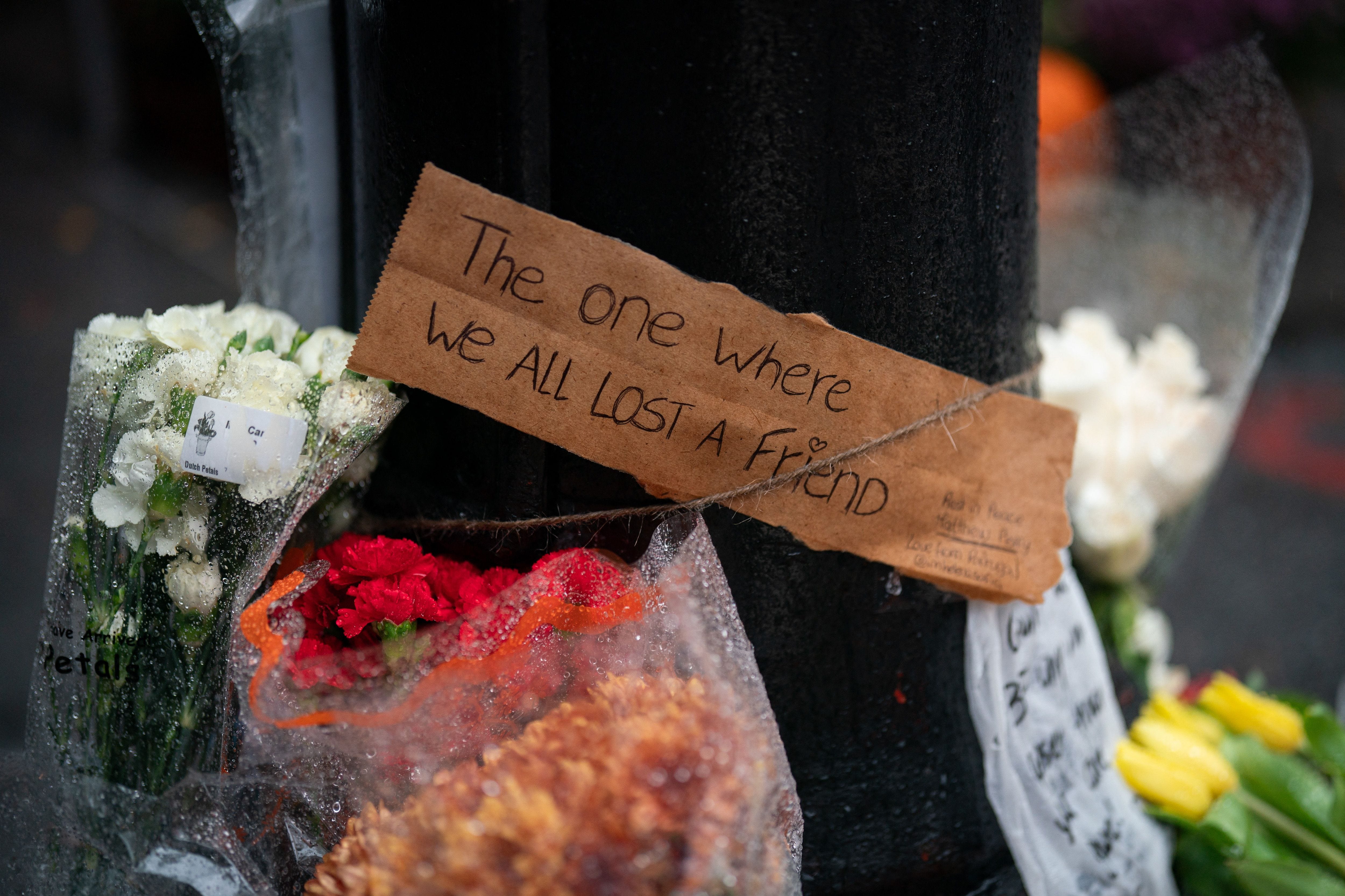 Floral tributes are left for actor Matthew Perry outside the apartment building which was used as the exterior shot in the TV show "Friends" in New York on October 29, 2023. Perry, 54, was known globally for his portrayal of wise-cracking character Chandler Bing on the wildly popular "Friends," which ran for 10 seasons from 1994 to 2004. First responders found Perry unconscious in a hot tub at his house on October 28 and were unable to revive   him, law enforcement sources told the Los Angeles Times. Police confirmed they'd mounted a "death investigation for a male in his 50s." (Photo by Adam GRAY / AFP) (Photo by ADAM GRAY/AFP via Getty Images) ORG XMIT: 775920236 ORIG FILE ID: 1752999066