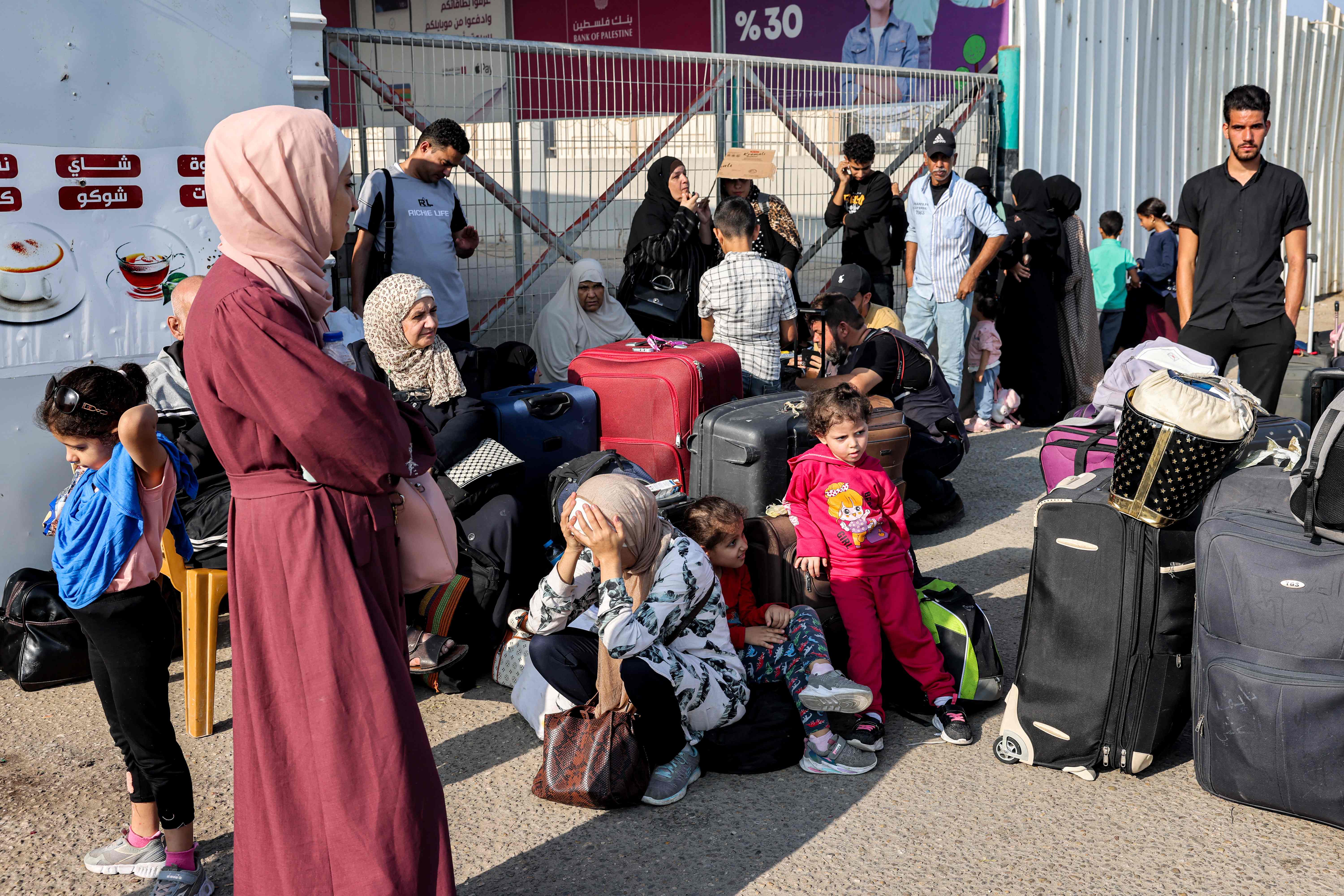 People wait at the Rafah border crossing with Egypt in the southern Gaza Strip on November 1, 2023. Egypt is preparing to treat wounded Palestinians from the bombarded Gaza Strip starting November 1, with the opening of a border crossing to people after weeks of war, medical and security sources said.
