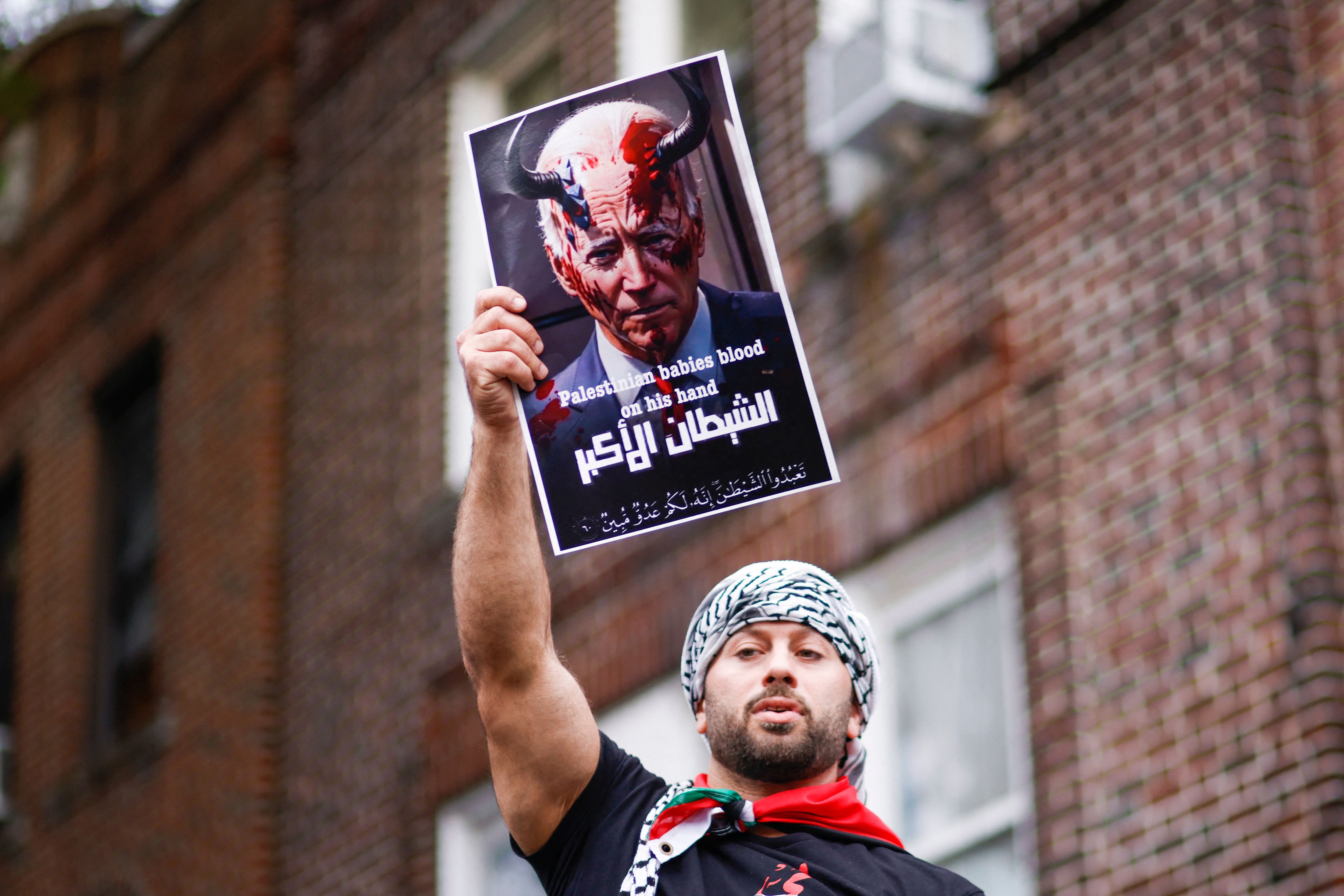 A man holds a sign depicting US President Joe Biden as the devil as people rally in support of Palestinians in Brooklyn, New York on October 21, 2023, amid ongoing conflict between Israel and Hamas. (Photo by KENA BETANCUR / AFP) (Photo by KENA BETANCUR/AFP via Getty Images) ORIG FILE ID: AFP_33YW8B2.jpg