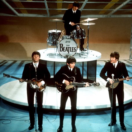 FILE -The Beatles, foreground from left, Paul McCartney, George Harrison, John Lennon and Ringo Starr on drums perform on the CBS "Ed Sullivan Show" in New York on Feb. 9, 1964. Sixty years after the onset of Beatlemania and with two of the quartet now dead, artificial intelligence has enabled the release of a 