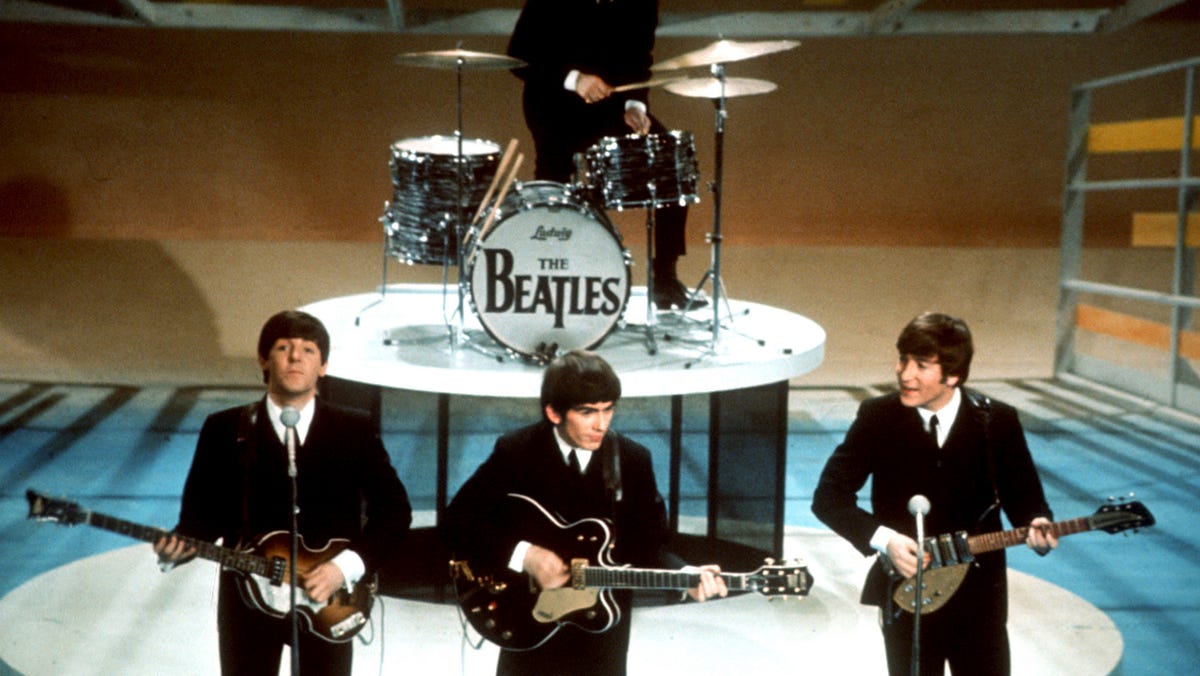 FILE -The Beatles, foreground from left, Paul McCartney, George Harrison, John Lennon and Ringo Starr on drums perform on the CBS "Ed Sullivan Show" in New York on Feb. 9, 1964. Sixty years after the onset of Beatlemania and with two of the quartet now dead, artificial intelligence has enabled the release of a 