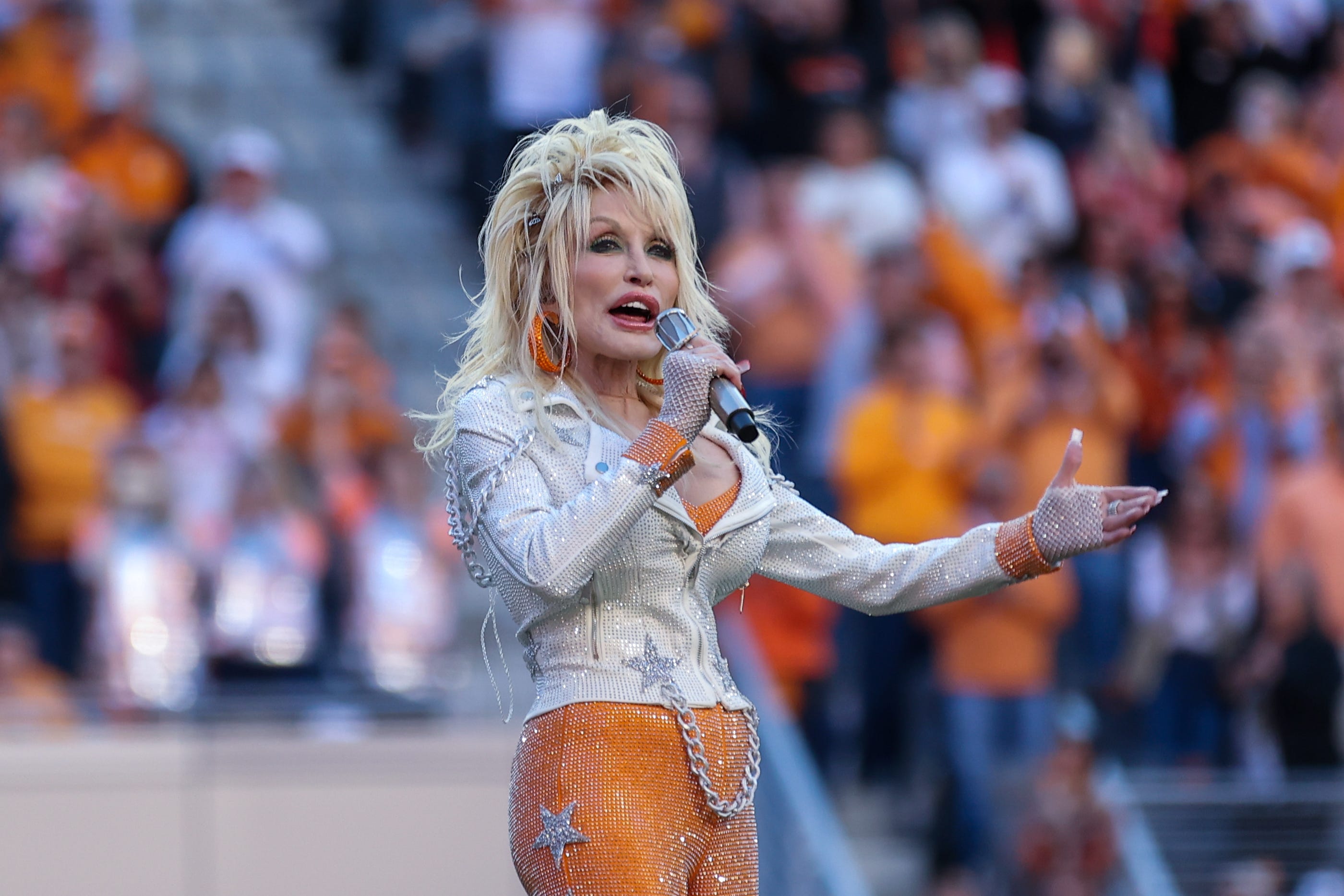 Country music artist Dolly Parton sings to the crowd during a break in a game between the Tennessee Volunteers and the Georgia Bulldogs at Neyland Stadium.