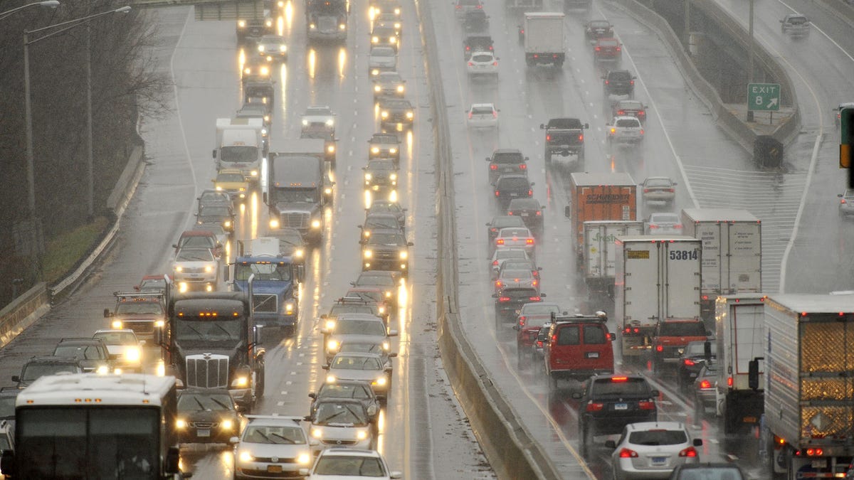 Traffic crawls along Interstate 95 as sleet falls during the beginning of a snowstorm in Connecticut on the day before Thanksgiving in 2014. More 'miserable' travel is expected Tuesday in the Mid-Atlantic, forecasters said.