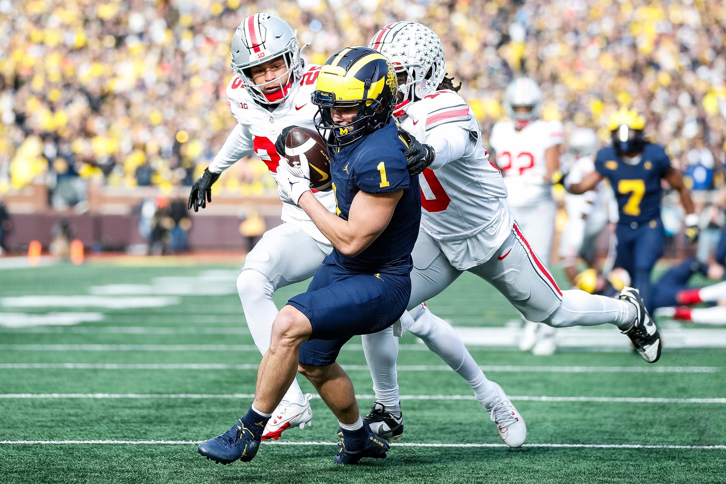 Michigan wide receiver Roman Wilson makes a catch for a touchdown against the defense of Ohio State's Malik Hartford and Denzel Burke during the first half at Michigan Stadium in Ann Arbor on Saturday, Nov. 25, 2023.