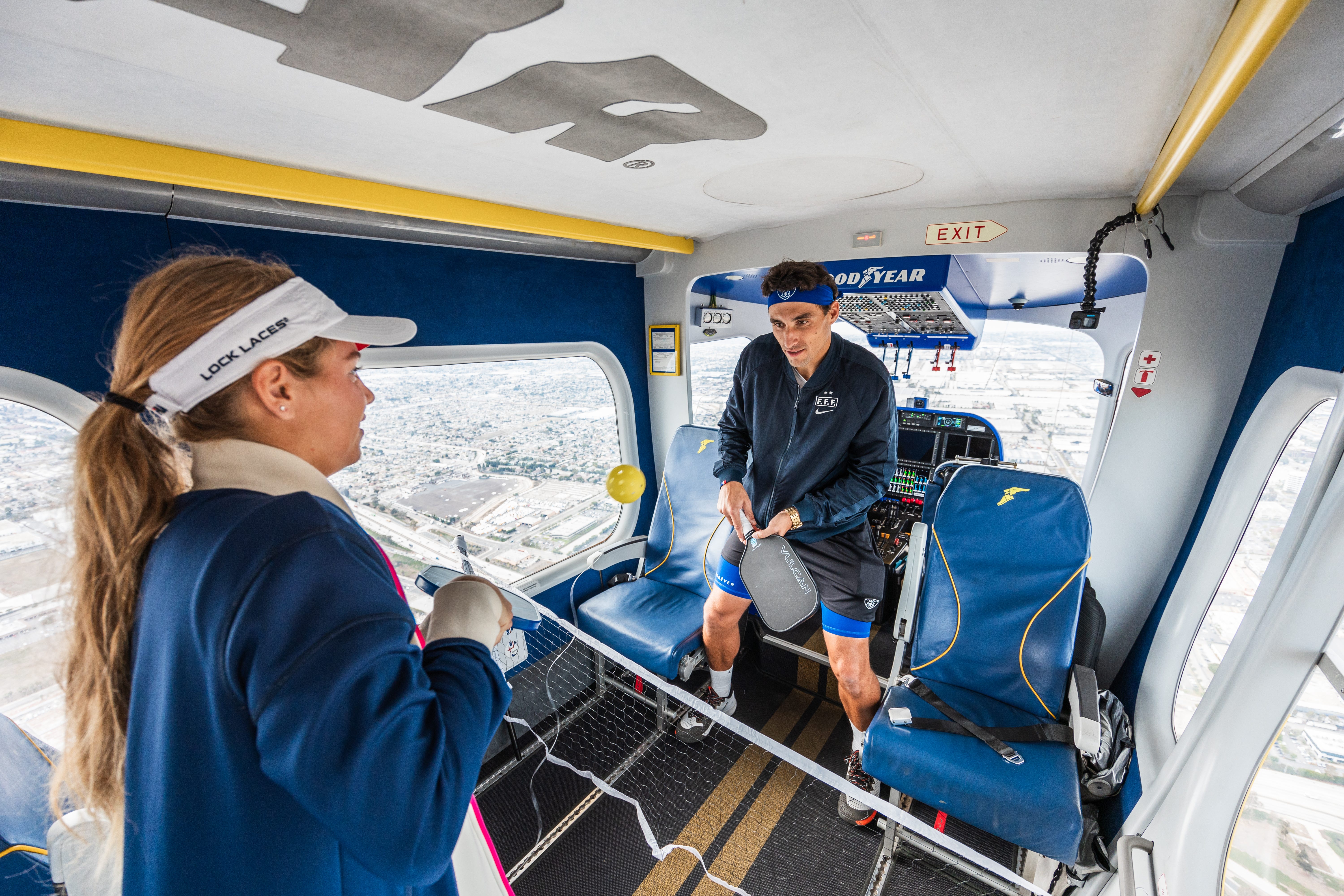 Anna Leigh Waters and Jay Devilliers enjoy pickleball mere inches from the open cockpit of the Goodyear Blimp, about 1,500 feet in the air.