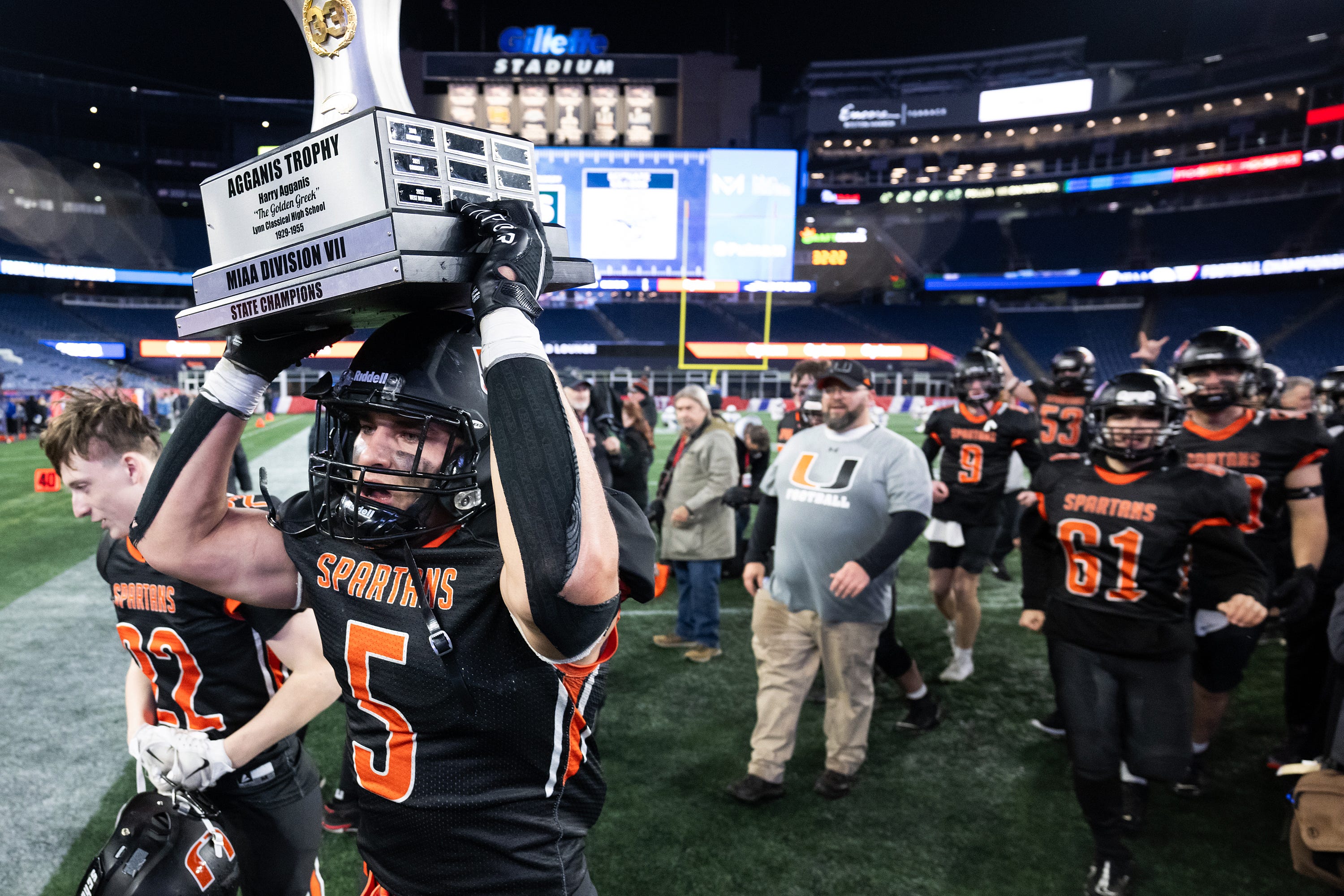 Uxbridge's Aidan Blood carries the trophy after defeating Amesbury in the Division 7 Super Bowl at Gillette Stadium on Friday December 1, 2023.