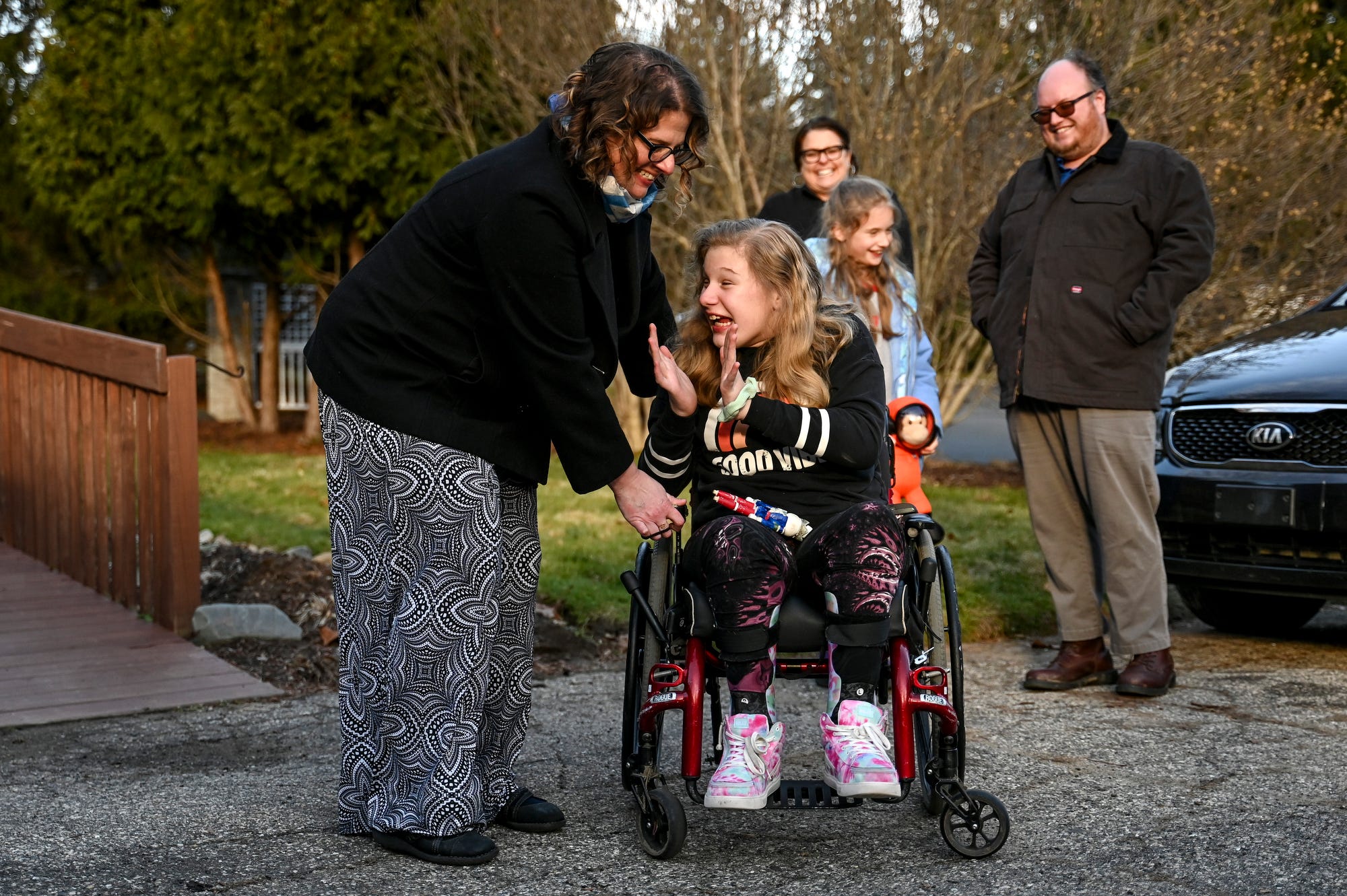 Sophie Ten Broeke, 11, right, reacts after her mother Megan, left, surprised Sophie with an electric wheelchair on Thursday, Dec. 7, 2023, outside their home in Lansing. Megan purchased the wheelchair at an affordable price from a Volunteers of America Michigan Thrift Store.