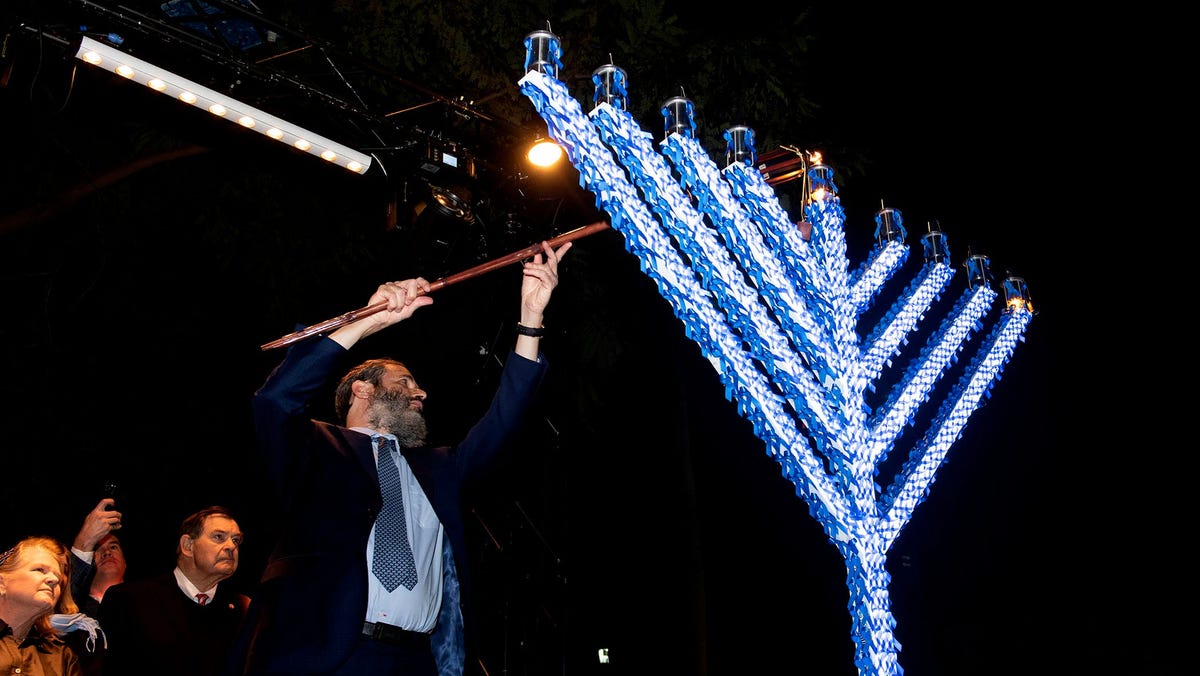 Rabbi Moshe Scheiner of Palm Beach Synagogue lights the menorah on the first night of Hanukkah during the annual Hanukkah event at Bradley Park December 8, 2023 in Palm Beach.