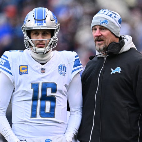 Lions coach Dan Campbell talks with quarterback Jared Goff (16) during the first half against the Bears at Soldier Field in Chicago on Dec. 10, 2023.