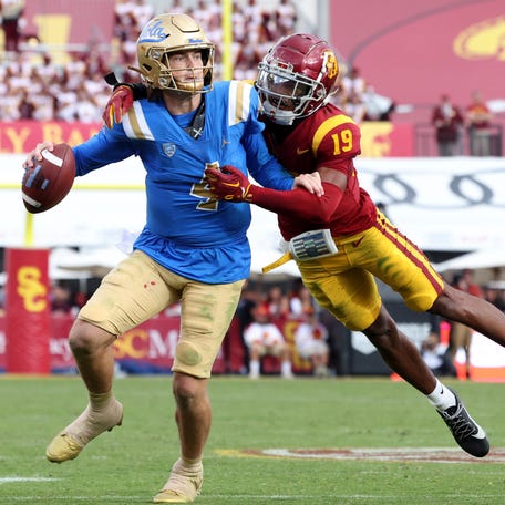 UCLA quarterback Ethan Garbers (4) scrambles to throw while under pressure from Southern California safety Jaylin Smith (19) during their game at United Airlines Field at Los Angeles Memorial Coliseum.