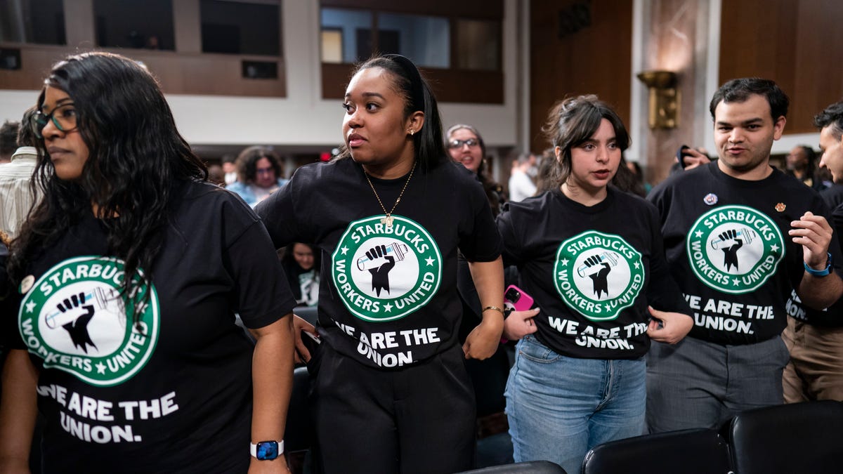 File - Advocates for a union for Starbucks employees watch as company founder Howard Schultz leaves a hearing after testifying to the Senate Health, Education, Labor and Pensions Committee at the Capitol in Washington on March 29, 2023.