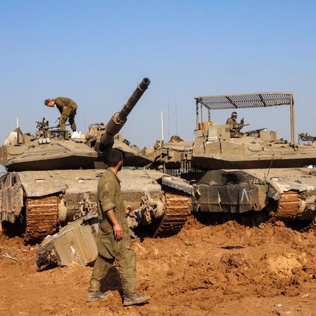Israeli soldiers carry out maintenance on an tanks near the border with the Gaza Strip on December 15, 2023, amid ongoing battles between Israel and the Palestinian militant group Hamas.