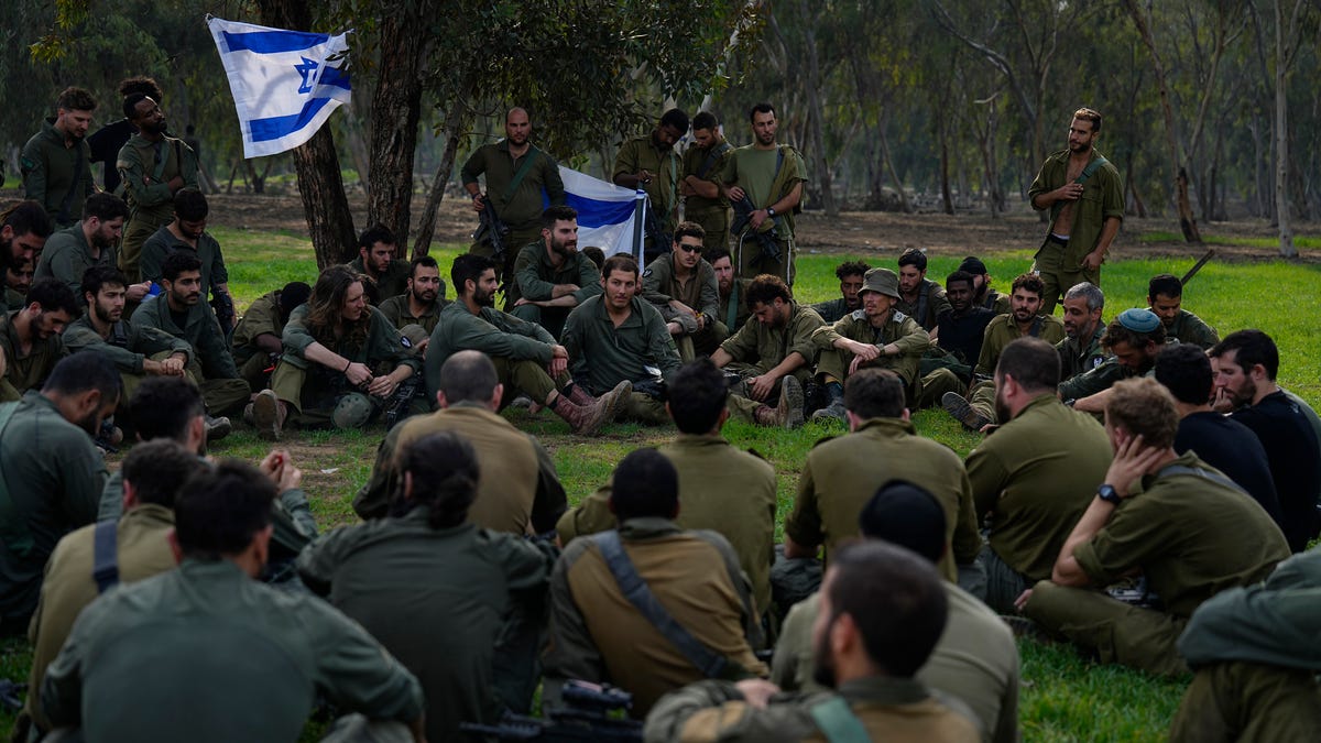 Israeli soldiers are briefed after coming back from the Gaza Strip at a staging area in southern Israel, Sunday, Dec. 17, 2023.