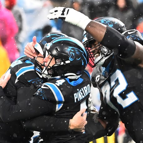Carolina Panthers place kicker Eddy Pineiro (4) hits a game winning field goal and celebrates with punter Johnny Hekker (10) and offensive tackle Taylor Moton (72) in the fourth quarter at Bank of America Stadium.
