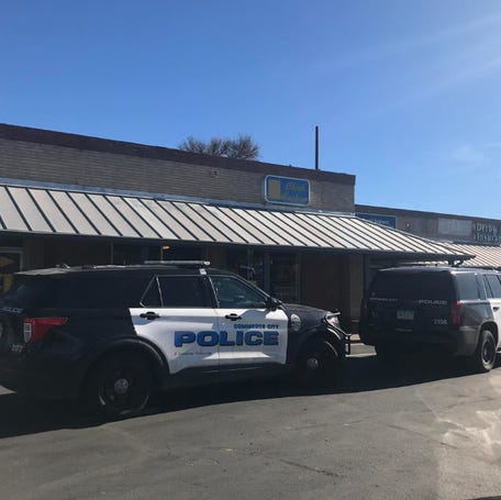 Commerce City police officers parked outside a business where officials say three, armed and masked men robbed a Denver-area check cashing business. In an ironic twist, police said, the suspects' vehicle was stolen during the armed robbery.