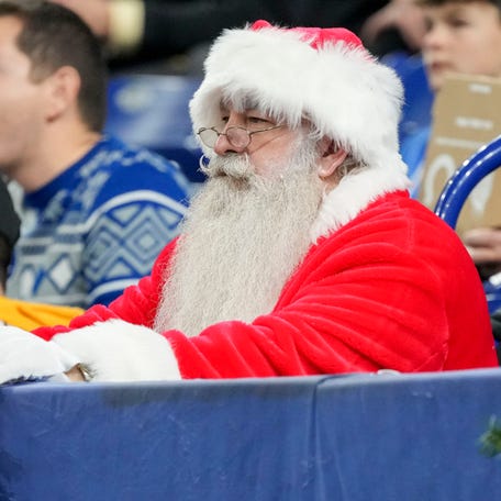 A fan dressed as Santa looks out on the field during a game between the Indianapolis Colts and the Pittsburgh Steelers at Lucas Oil Stadium.