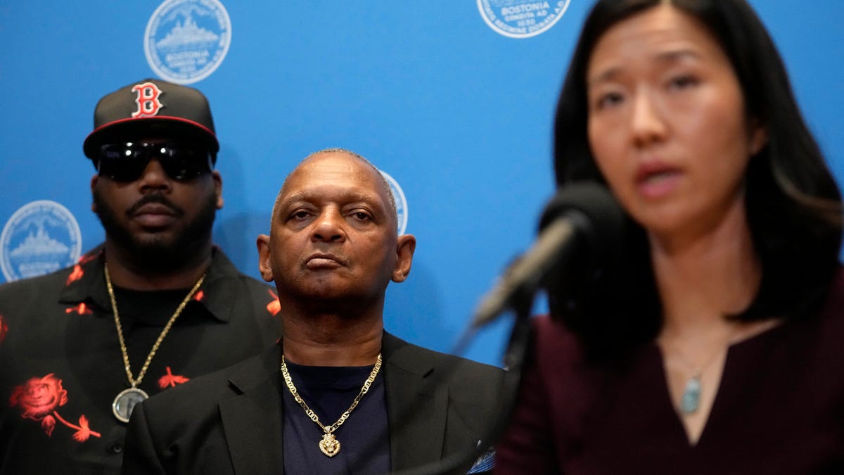 Alan Swanson, center, stands with Boston Mayor Michelle Wu, right, as Wu offers a formal apology to Swanson and Willie Bennett, not shown, during a news conference, Wednesday, Dec. 20, 2023, in Boston. Wu issued a formal apology to Swanson and Bennett Wednesday for their wrongful arrests following the 1989 death of Carol Stuart, whose husband, Charles Stuart, had orchestrated her murder. (AP Photo/Steven Senne) ORG XMIT: MASR107