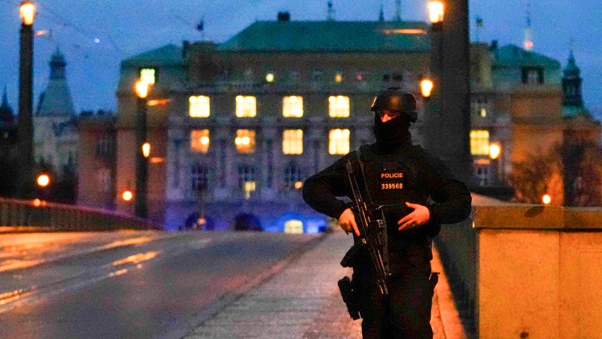 December 21, 2023: A police officer walks across a bridge over the Vltava river in downtown Prague, Czech Republic, Thursday, Dec. 21, 2023. Czech police say a shooting in downtown Prague has killed an unspecified number of people and wounded others.