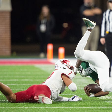 68 Ventures Bowl: Eastern Michigan QB Cam'Ron McCoy goes airborne after being tackled by South Alabama safety Jaden Voisin (2).