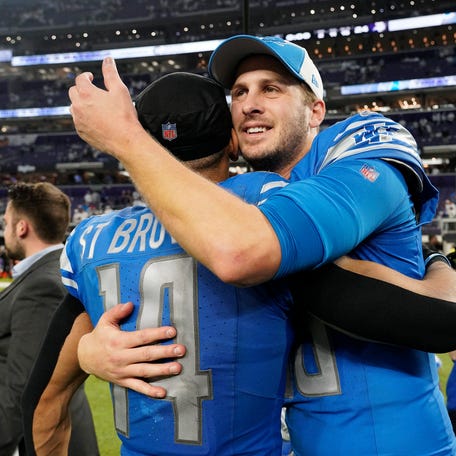 Jared Goff #16 and Amon-Ra St. Brown #14 of the Detroit Lions celebrate the 30-24 win against the Minnesota Vikings at U.S. Bank Stadium on December 24, 2023 in Minneapolis, Minnesota.