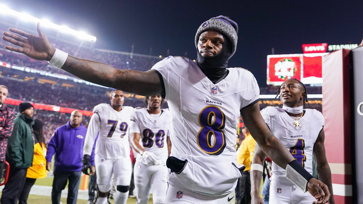 Lamar Jackson #8 of the Baltimore Ravens high fives a fan while heading into the locker room after the first half against the San Francisco 49ers at Levi's Stadium on December 25, 2023 in Santa Clara, California.