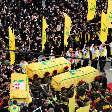 Hezbollah fighters carry the coffins of a Hezbollah fighter and other two civilians who were killed by an Israeli airstrike that hit their house Tuesday night, during their funeral processions, in Bint Jbeil, South Lebanon, Wednesday, Dec. 27, 2023.