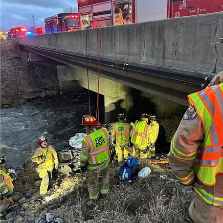 Police rescue a man from his damaged vehicle Tuesday, Dec. 26, 2023 along Interstate 94 near Portage, Ind. Authorities say the man drank rainwater to survive the ordeal while pinned in the wreckage beneath the Indiana highway bridge.