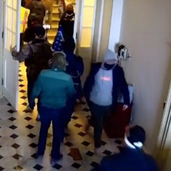 Capitol security footage from Jan. 6. This angle shows the man in the blue coat, who is also wearing pink shoes, turn around and walk back down the corridor.