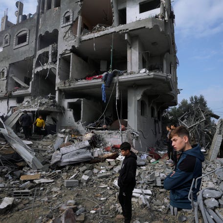 Palestinians inspect the rubble of a building of the Al Nawasrah family destroyed in an Israeli strike in Maghazi refugee camp, central Gaza Strip, Monday, Dec. 25, 2023.
