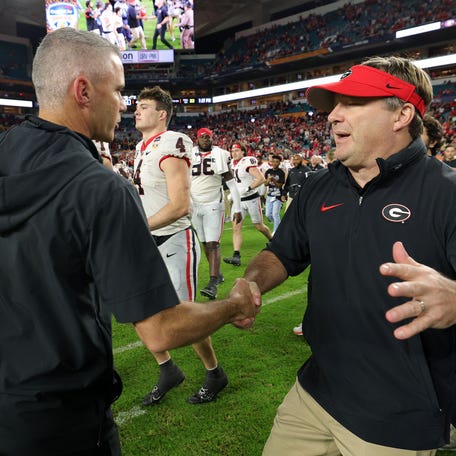 Dec 30, 2023; Miami Gardens, FL, USA; Georgia Bulldogs head coach Kirby Smart (right) shakes hands with Florida State Seminoles head coach Mike Norvell (left) after the 2023 Orange Bowl at Hard Rock Stadium. Mandatory Credit: Nathan Ray Seebeck-USA TODAY Sports