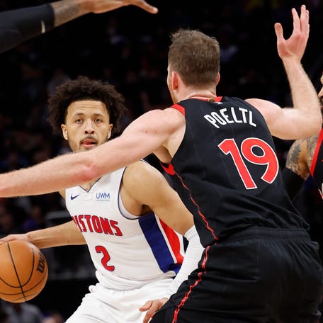 Detroit Pistons guard Cade Cunningham (2) dribbles while defended by Toronto Raptors center Jakob Poeltl (19) in the first half at Little Caesars Arena.
